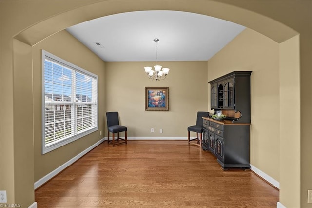 living area featuring hardwood / wood-style floors and an inviting chandelier