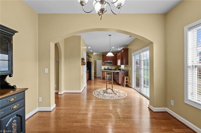 interior space with wood-type flooring and an inviting chandelier