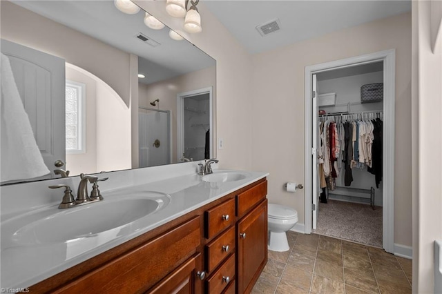 bathroom with a shower, vanity, and toilet