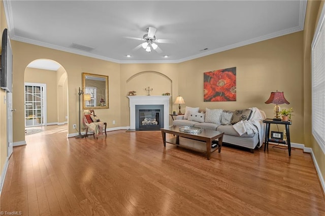 living room featuring hardwood / wood-style floors, ceiling fan, and ornamental molding