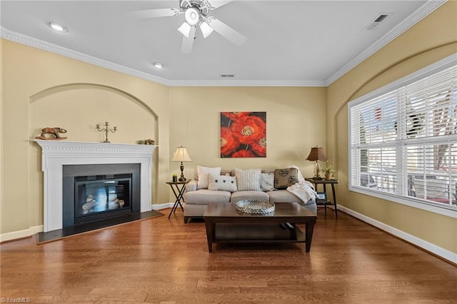 living room with hardwood / wood-style floors, ceiling fan, and crown molding