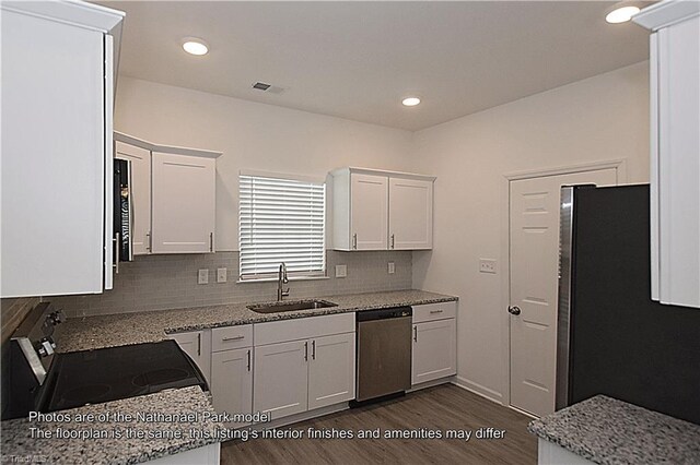 kitchen with backsplash, dark wood-style flooring, appliances with stainless steel finishes, a sink, and white cabinets
