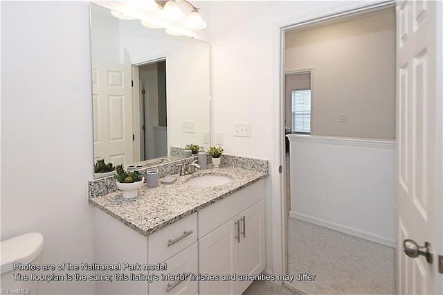 bathroom featuring vanity, baseboards, and toilet