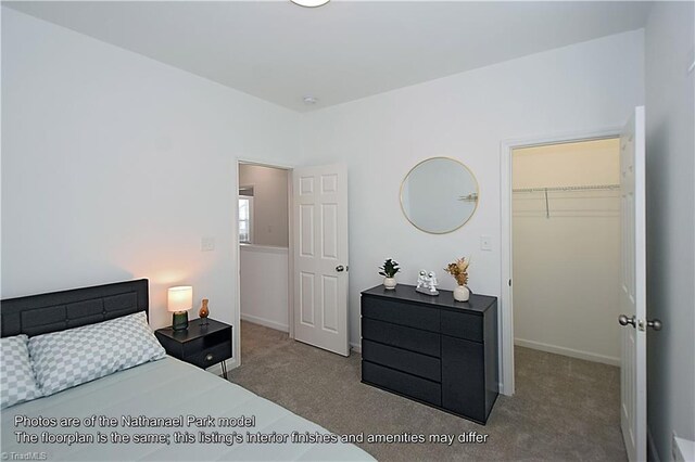 carpeted bedroom featuring a closet, baseboards, and a spacious closet