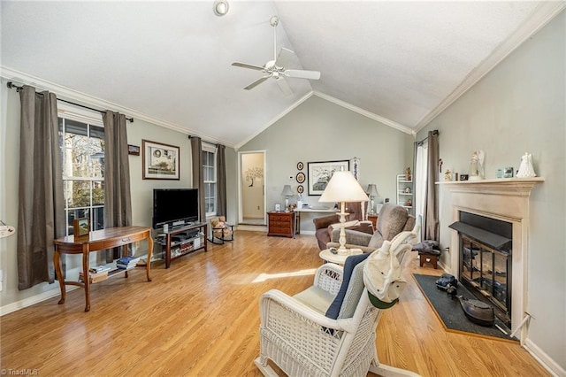 living room with crown molding, lofted ceiling, ceiling fan, and light wood-type flooring