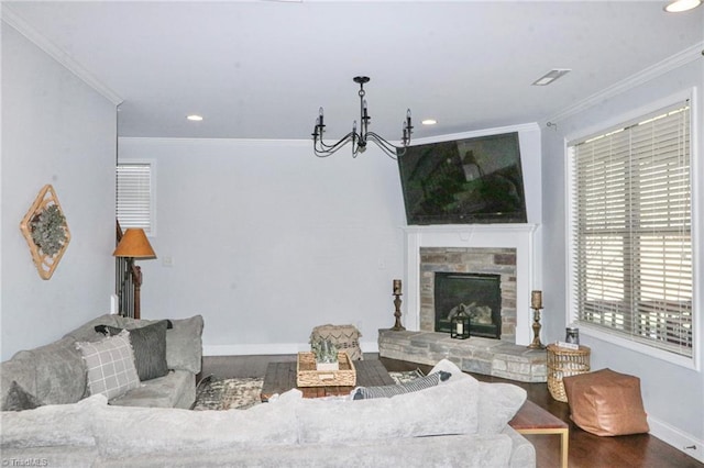 living room with hardwood / wood-style floors, an inviting chandelier, crown molding, and a fireplace