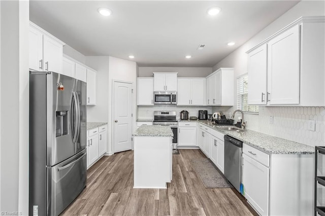 kitchen with appliances with stainless steel finishes, a center island, sink, and white cabinets