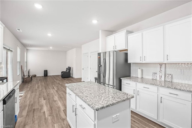 kitchen with light stone countertops, stainless steel appliances, and white cabinets