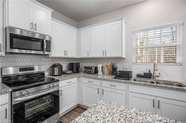 kitchen with sink, white cabinets, and appliances with stainless steel finishes