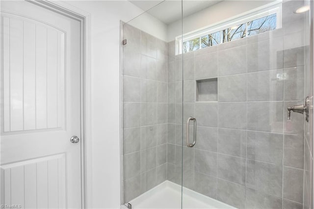 bathroom with a shower with door