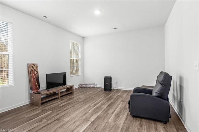 living area with plenty of natural light and hardwood / wood-style floors