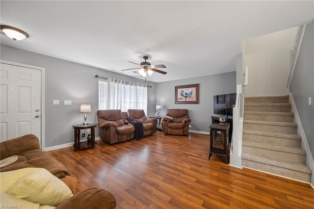 living room featuring dark wood-type flooring and ceiling fan