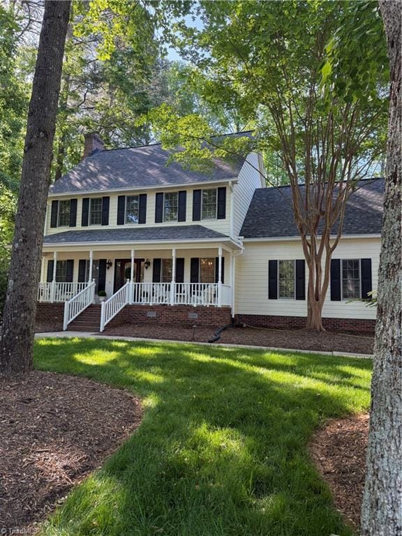 1005 Stuart Dr, Mebane, NC 27302 - colonial house with a chimney, roof with shingles, a front yard, and a porch