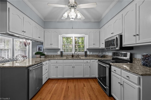 1005 Stuart Dr, Mebane, NC 27302 - kitchen featuring a sink, a peninsula, white cabinets, and stainless steel appliances