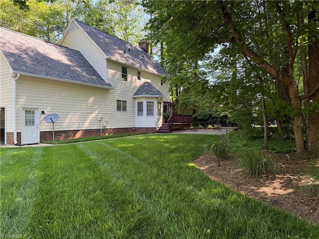 1005 Stuart Dr, Mebane, NC 27302 - back of property with a lawn, a shingled roof, a wooden deck, and a chimney
