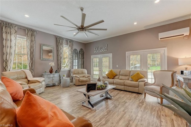 living room featuring french doors, ornamental molding, ceiling fan, light wood-type flooring, and an AC wall unit