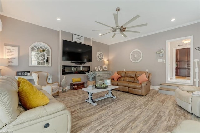 living room featuring ornamental molding, ceiling fan, and light hardwood / wood-style flooring