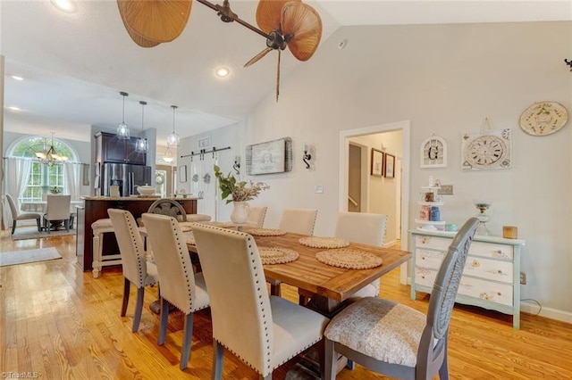 dining area with ceiling fan, light wood-type flooring, and high vaulted ceiling