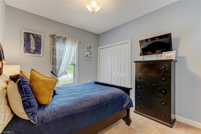 bedroom featuring light colored carpet and a closet