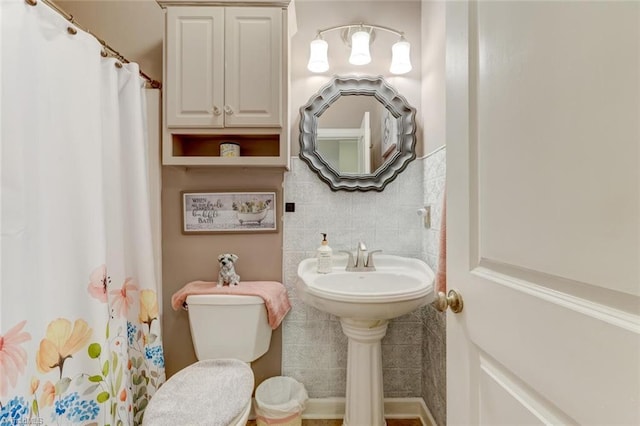 bathroom featuring tile walls and toilet