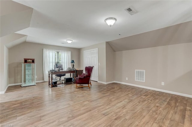 sitting room with light wood-type flooring and lofted ceiling