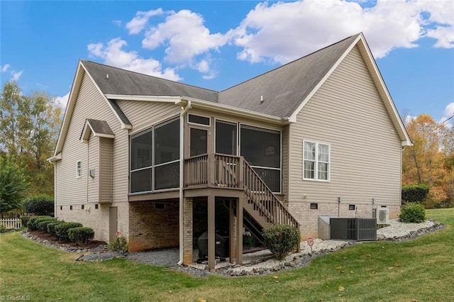 rear view of house featuring a sunroom and a yard