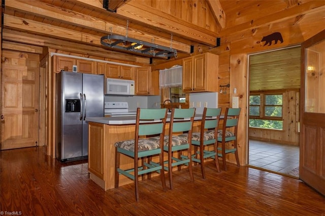 158 Cottontail Ln, North Wilkesboro, NC 28659 - kitchen featuring white appliances, wooden walls, dark wood finished floors, beam ceiling, and a peninsula