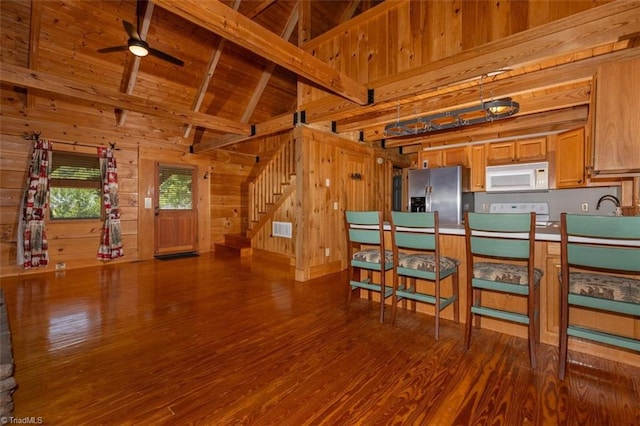 158 Cottontail Ln, North Wilkesboro, NC 28659 - kitchen with white microwave, stainless steel fridge with ice dispenser, wooden walls, wood finished floors, and a ceiling fan