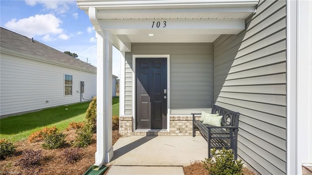 view of exterior entry featuring covered porch