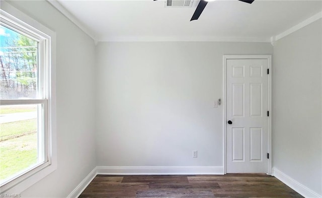 spare room featuring dark wood-style floors, a wealth of natural light, and baseboards