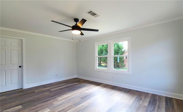 empty room featuring baseboards, dark wood-type flooring, visible vents, and crown molding