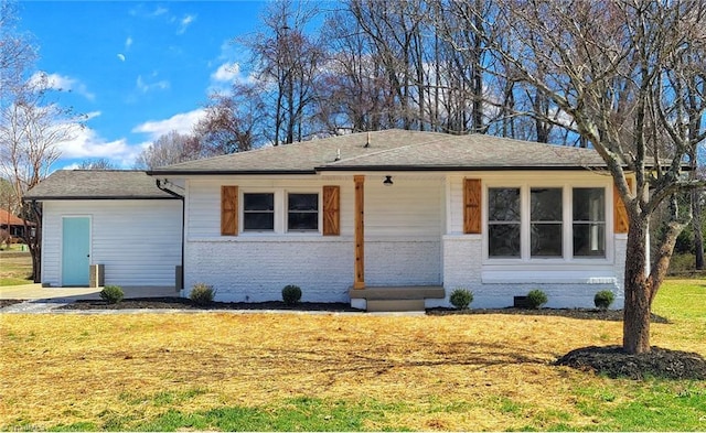 ranch-style home featuring brick siding, crawl space, and a front lawn