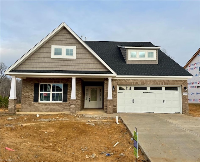 craftsman inspired home featuring a garage and covered porch