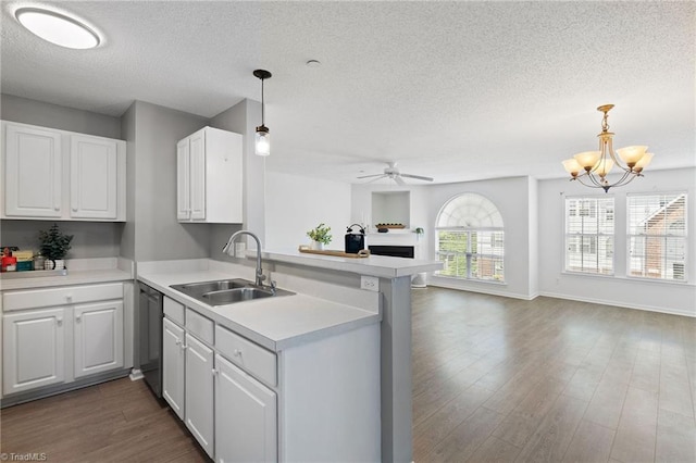4290 Cedarcroft Ct Unit 2A, Greensboro, NC 27409 - kitchen featuring a sink, a peninsula, a textured ceiling, open floor plan, and white cabinets