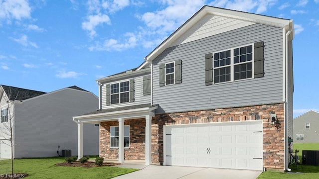 view of property featuring a garage, a front lawn, and central air condition unit