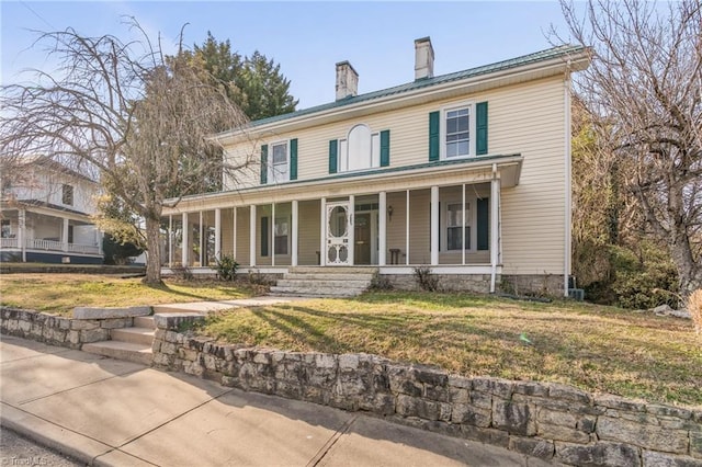 view of front of home with covered porch and a front lawn