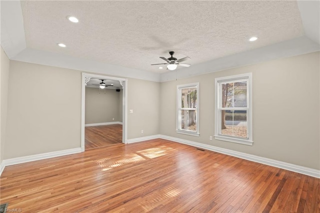 unfurnished room with a textured ceiling, wood-type flooring, and ceiling fan