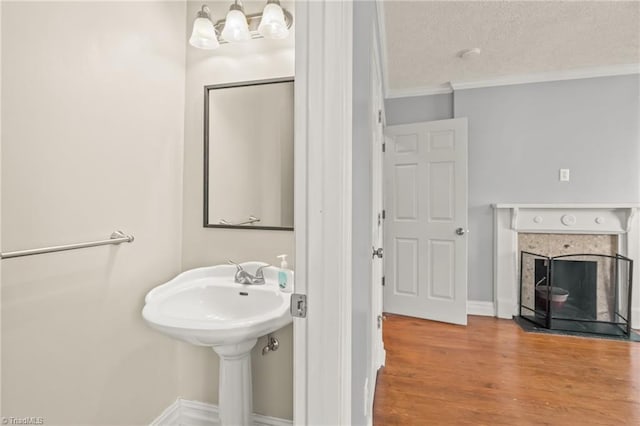 bathroom with a textured ceiling, hardwood / wood-style flooring, and ornamental molding