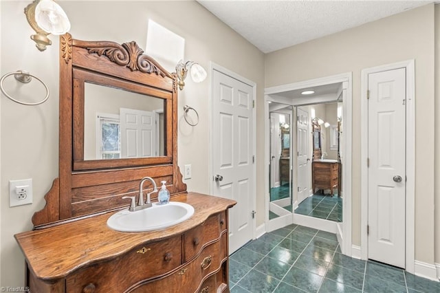 bathroom featuring vanity, a textured ceiling, and tile floors