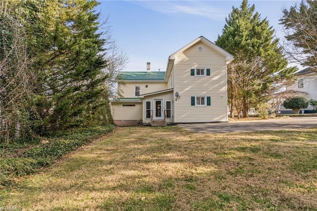 rear view of property with a lawn