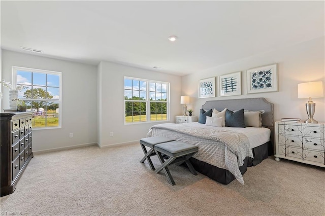 bedroom with visible vents, multiple windows, light carpet, and baseboards