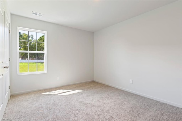 carpeted empty room featuring visible vents and baseboards