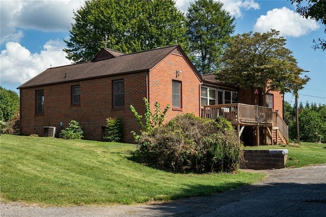 view of home's exterior featuring central AC unit, a deck, and a yard