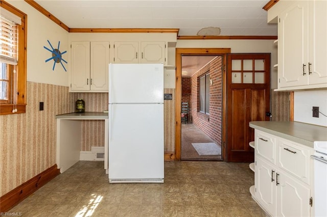 kitchen featuring white cabinets, crown molding, and white fridge