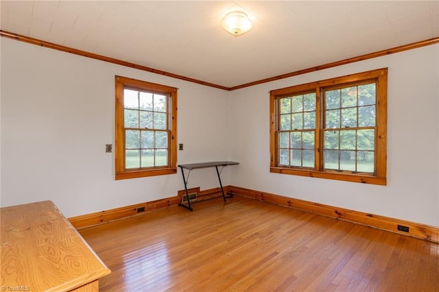 empty room featuring crown molding and wood-type flooring