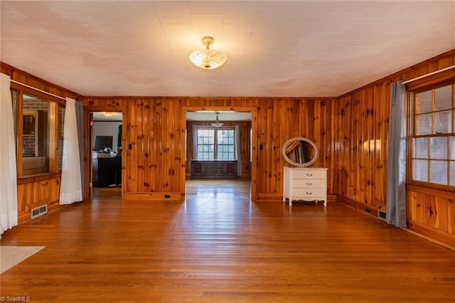 unfurnished room featuring wood walls and wood-type flooring