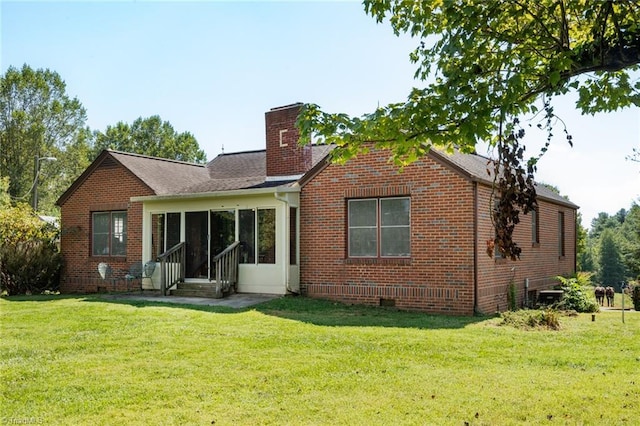 back of property with a lawn and a sunroom