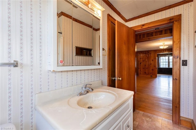 bathroom with crown molding, vanity, and hardwood / wood-style flooring