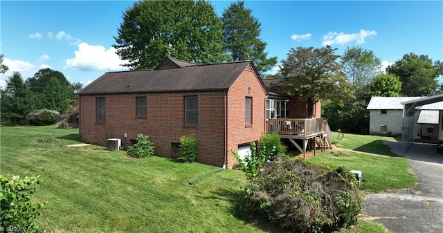 view of side of home featuring a lawn, a garage, central air condition unit, and a wooden deck