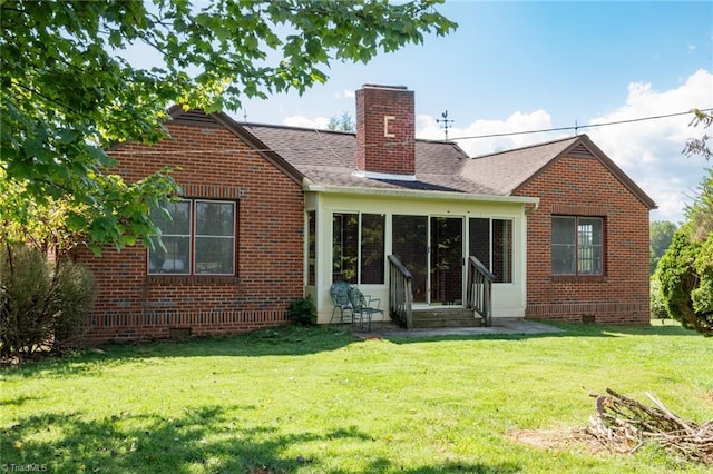 back of house featuring a lawn and a sunroom